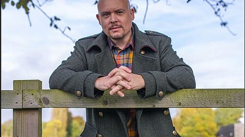 Cameron Thomas MP leaning on fence